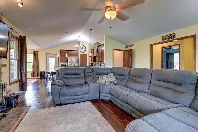 living room featuring dark wood-style floors, a chandelier, lofted ceiling, and ceiling fan