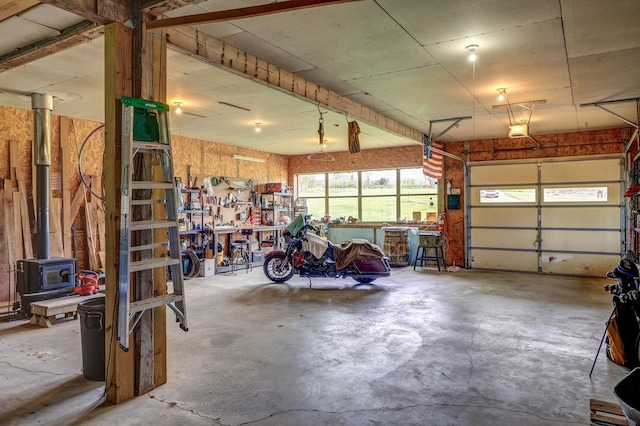 garage with a workshop area, a wood stove, and a garage door opener