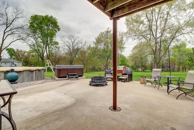 view of patio with a hot tub and a fire pit
