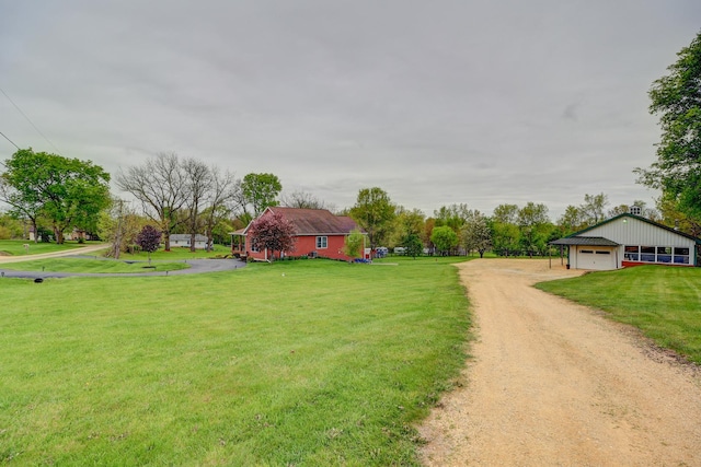 view of green lawn with a garage and driveway