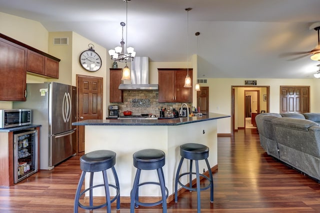 kitchen with wall chimney exhaust hood, wine cooler, dark wood finished floors, backsplash, and lofted ceiling