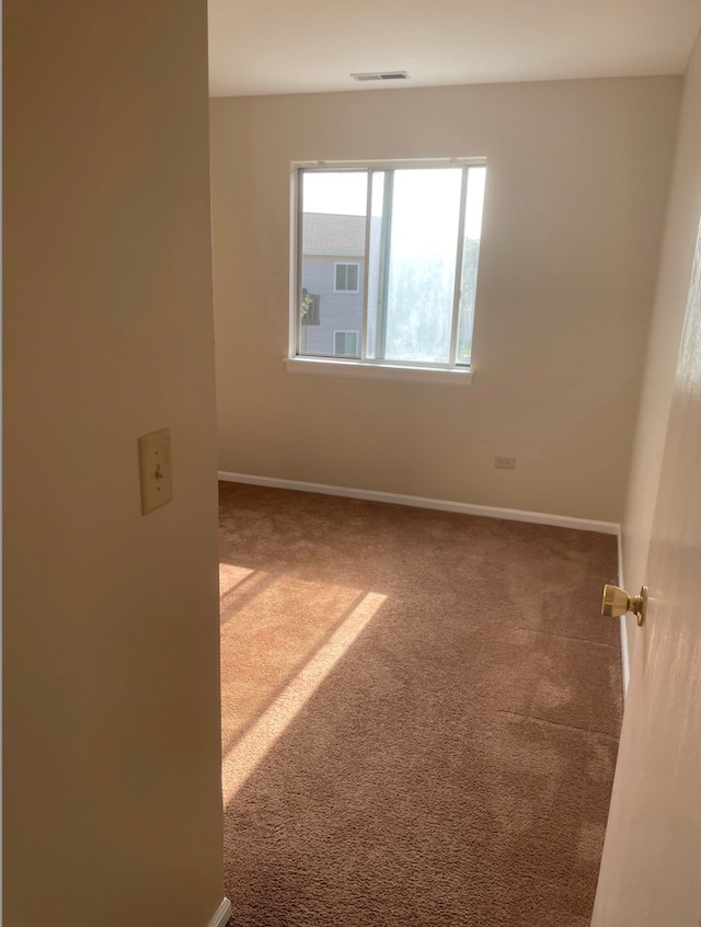 unfurnished room with carpet and baseboards