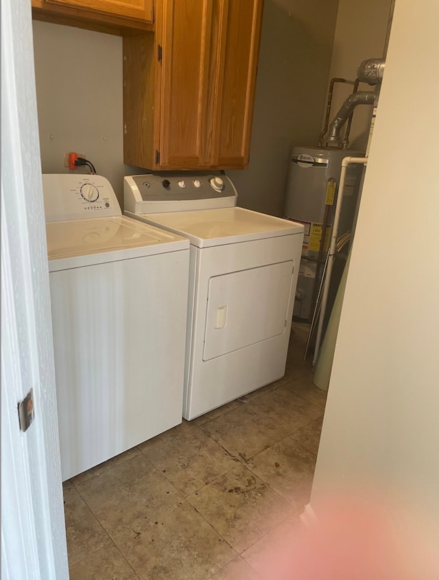 washroom with separate washer and dryer, cabinet space, gas water heater, and light tile patterned floors