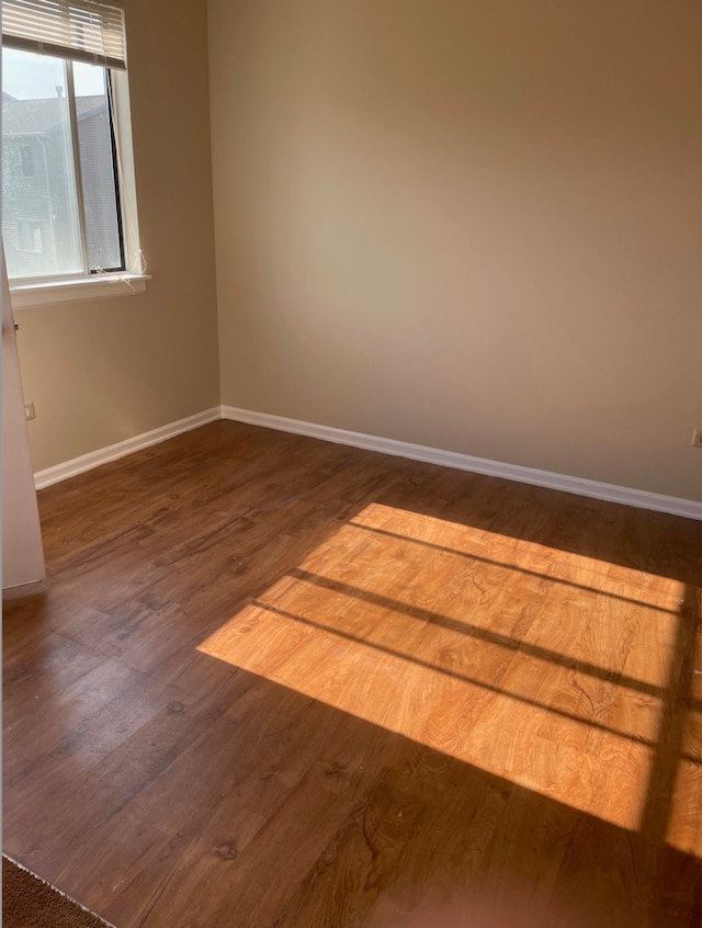 unfurnished room with wood finished floors and baseboards
