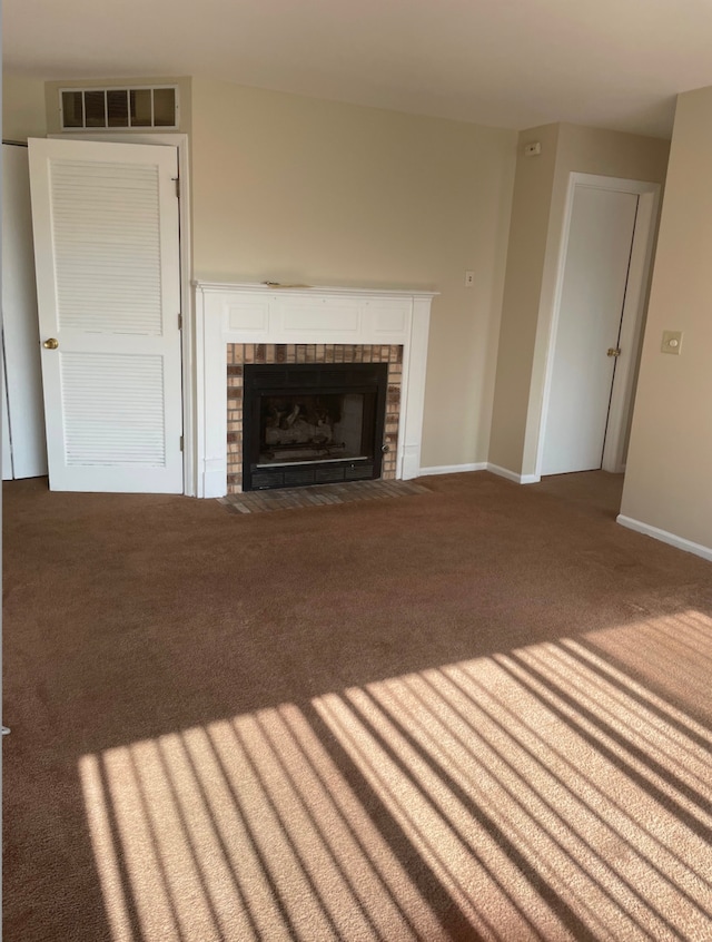 unfurnished living room with carpet flooring, a fireplace, and baseboards