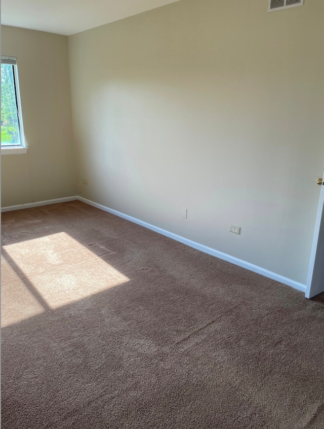 empty room featuring carpet flooring and baseboards