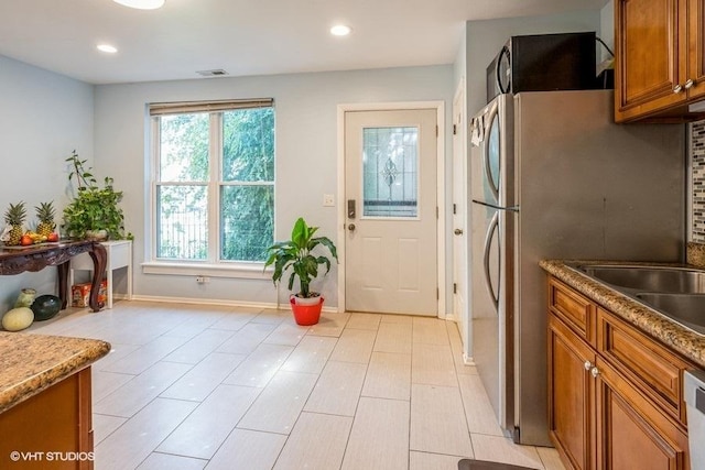 kitchen with brown cabinets, baseboards, decorative backsplash, recessed lighting, and stainless steel dishwasher