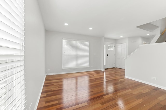10616 Rushmore Ln, Huntley, IL 60142 - unfurnished living room featuring hardwood / wood-style floors, baseboards, recessed lighting, and stairs