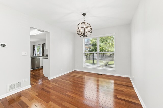 10616 Rushmore Ln, Huntley, IL 60142 - spare room with a chandelier, healthy amount of natural light, wood-type flooring, and baseboards