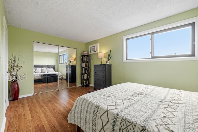 9935 El Cameno Real Dr Unit 3D, Orland Park, IL 60462 - bedroom with multiple windows, wood finished floors, a textured ceiling, baseboards, and a closet
