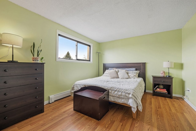 9935 El Cameno Real Dr Unit 3D, Orland Park, IL 60462 - bedroom with a baseboard radiator, light wood finished floors, baseboards, and a textured ceiling