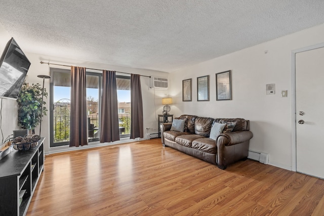 9935 El Cameno Real Dr Unit 3D, Orland Park, IL 60462 - living room with baseboard heating, a textured ceiling, light wood finished floors, and an AC wall unit