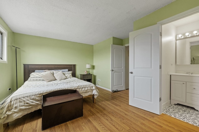 9935 El Cameno Real Dr Unit 3D, Orland Park, IL 60462 - bedroom featuring light wood-type flooring, a textured ceiling, ensuite bath, and baseboards
