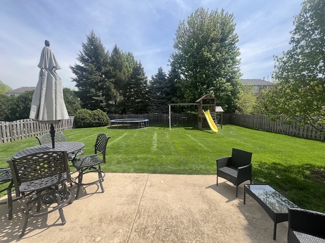 1932 Royal Ln, Aurora, IL 60503 - view of patio / terrace with a trampoline, outdoor dining area, and a playground