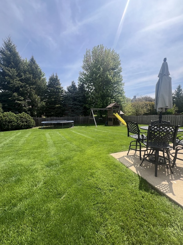 1932 Royal Ln, Aurora, IL 60503 - view of yard featuring a trampoline, a playground, and a patio area