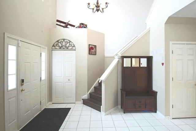 1932 Royal Ln, Aurora, IL 60503 - entryway with stairs, light tile patterned floors, a high ceiling, a chandelier, and baseboards
