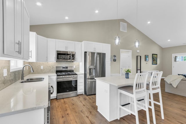 1608 E Horizon Ln, Urbana, IL 61802 - kitchen with appliances with stainless steel finishes, a sink, high vaulted ceiling, white cabinetry, and decorative backsplash