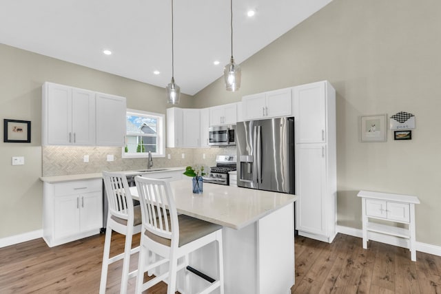 1608 E Horizon Ln, Urbana, IL 61802 - kitchen featuring appliances with stainless steel finishes, backsplash, white cabinets, vaulted ceiling, and recessed lighting