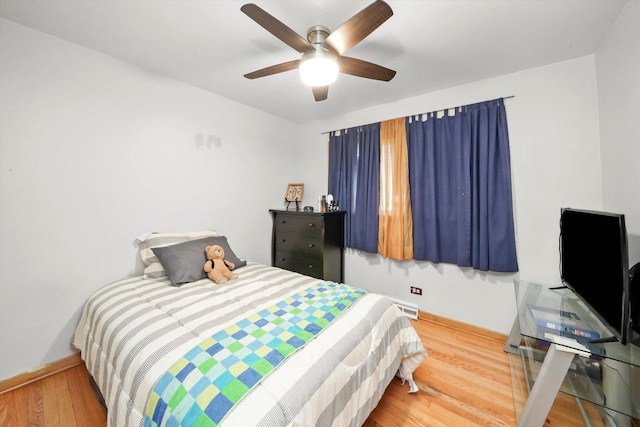 bedroom featuring wood finished floors, baseboards, and a ceiling fan