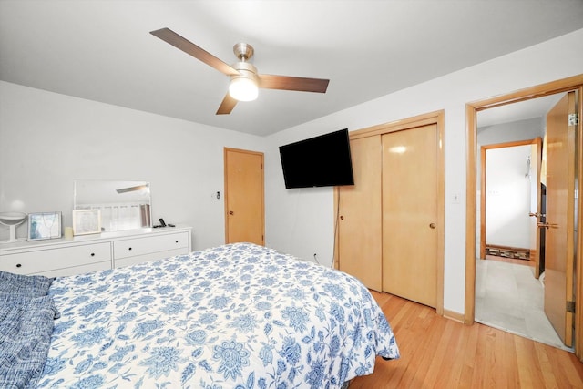 bedroom with light wood-style floors, a closet, and a ceiling fan