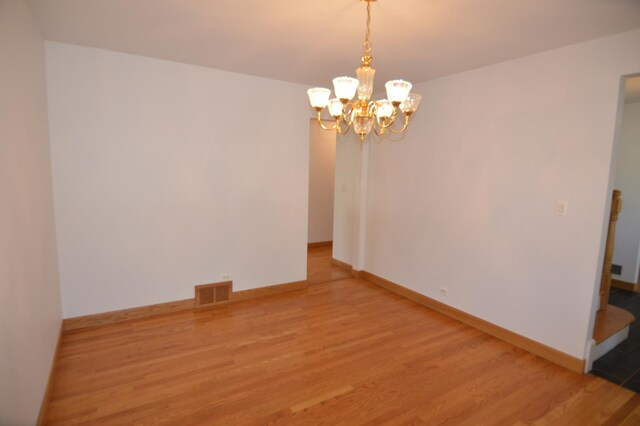 2405 E Miner St, Arlington Heights, IL 60004 - empty room with light wood-style flooring, a chandelier, and baseboards