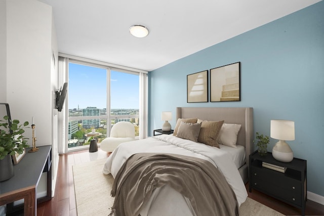 bedroom featuring a wall of windows and wood finished floors