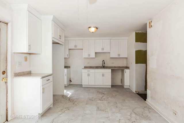 563 Lynn Ct Unit A, Glendale Heights, IL 60139 - kitchen featuring light marble finish floors, a sink, and white cabinets