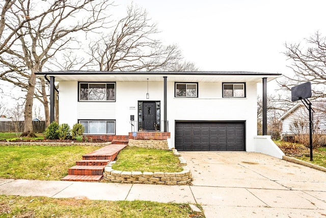 bi-level home with an attached garage, stucco siding, and driveway