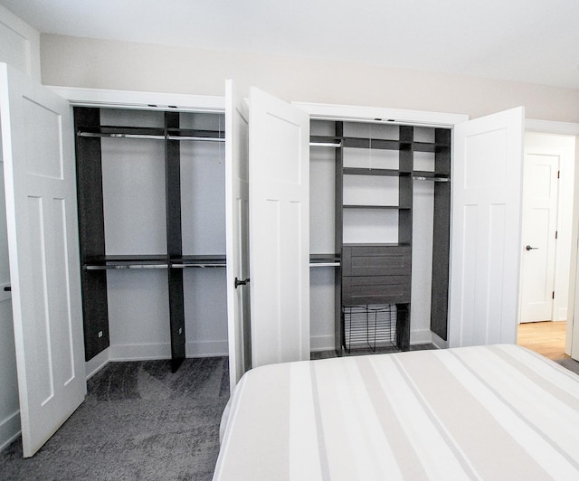 bedroom featuring multiple closets and baseboards