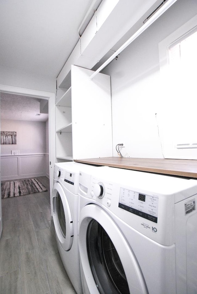washroom with washer and clothes dryer and wood finished floors