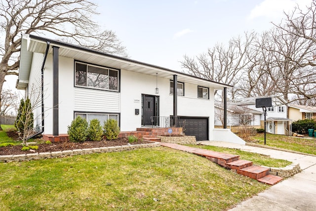 bi-level home featuring driveway, an attached garage, and a front lawn