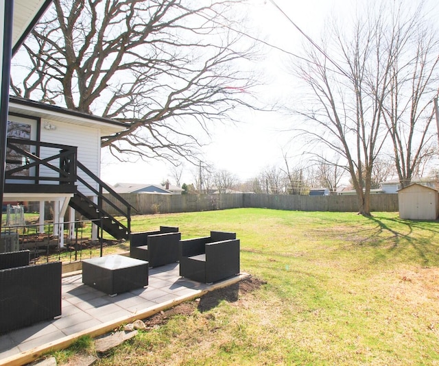 view of yard featuring a storage unit, a patio area, an outbuilding, stairs, and an outdoor living space