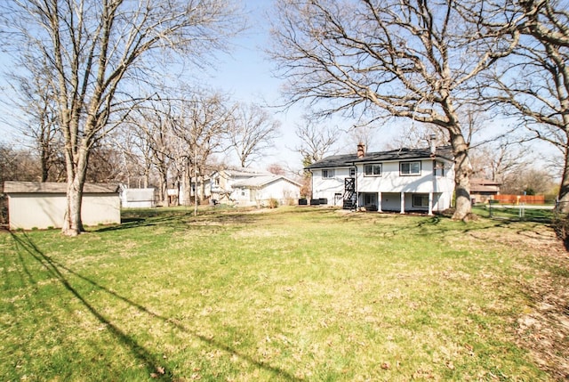 view of yard with an outbuilding, a storage unit, and stairway