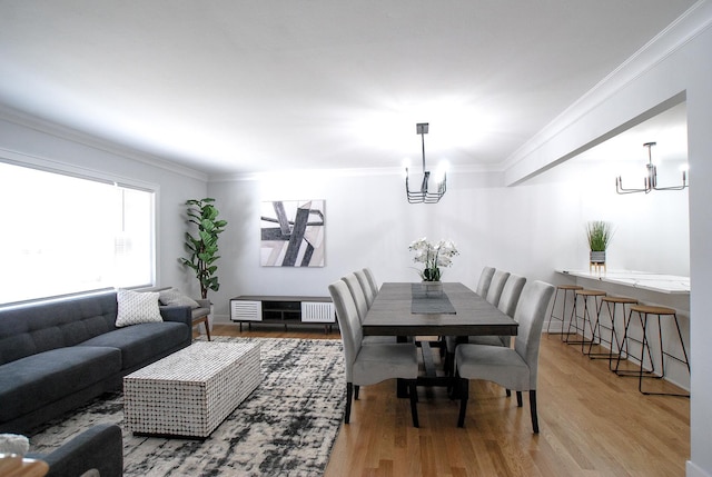 dining area with a chandelier, wood finished floors, crown molding, and radiator heating unit