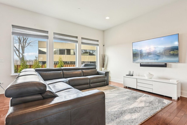 living room featuring plenty of natural light, wood finished floors, baseboards, and recessed lighting