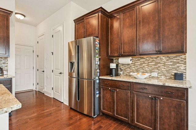 kitchen featuring stainless steel refrigerator with ice dispenser, dark wood-style floors, backsplash, and light stone countertops