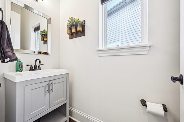 bathroom featuring vanity, plenty of natural light, and baseboards