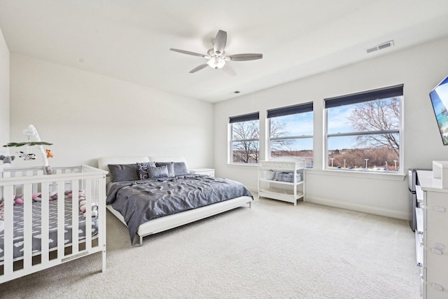 bedroom with light colored carpet, ceiling fan, and baseboards