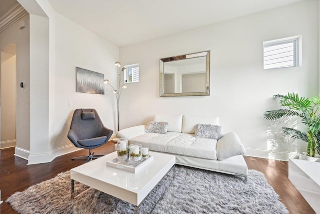 living area with baseboards, wood-type flooring, and healthy amount of natural light