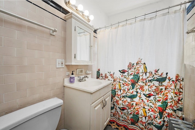 bathroom with toilet, vanity, tile walls, and curtained shower