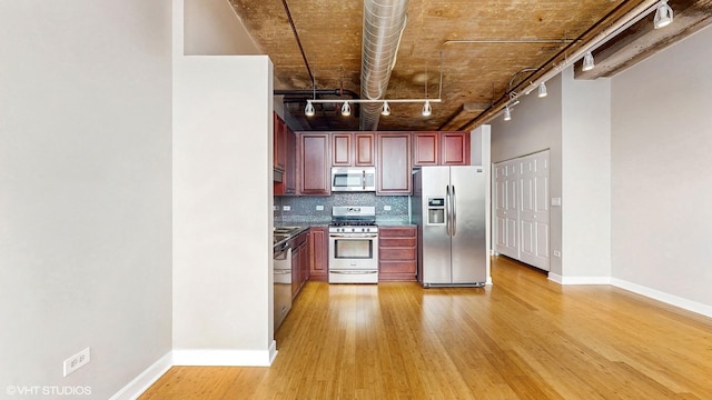 kitchen featuring stainless steel appliances, reddish brown cabinets, light wood-style flooring, backsplash, and baseboards