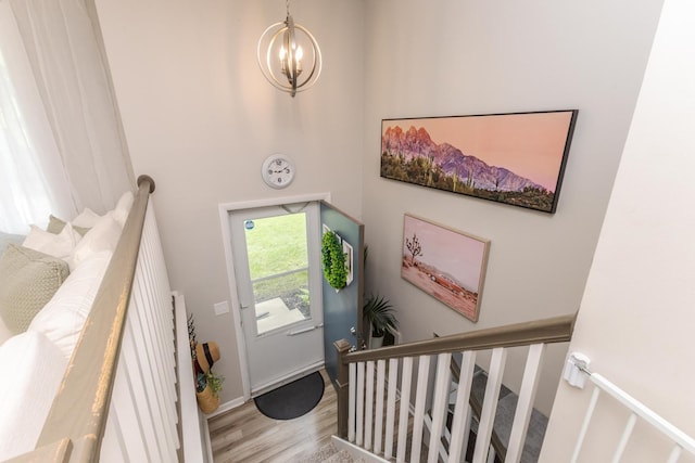 entrance foyer with a chandelier, wood finished floors, baseboards, and a high ceiling