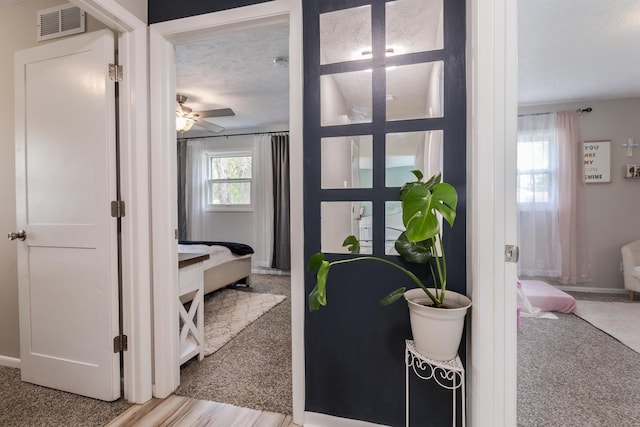 doorway featuring carpet flooring, a ceiling fan, and baseboards