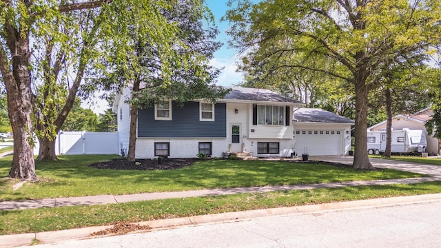 bi-level home with driveway, a garage, a chimney, and a gate