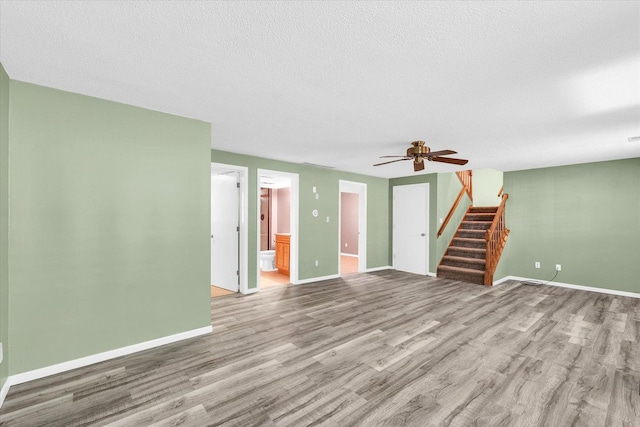 123 E 14th St, Gibson City, IL 60936 - unfurnished living room with stairway, wood finished floors, ceiling fan, baseboards, and a textured ceiling