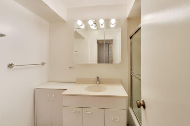full bath with vanity and bath / shower combo with glass door