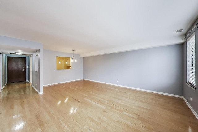 unfurnished living room featuring baseboards and light wood finished floors