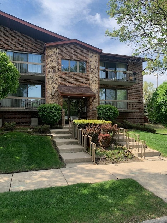 view of front of property featuring brick siding and a front yard
