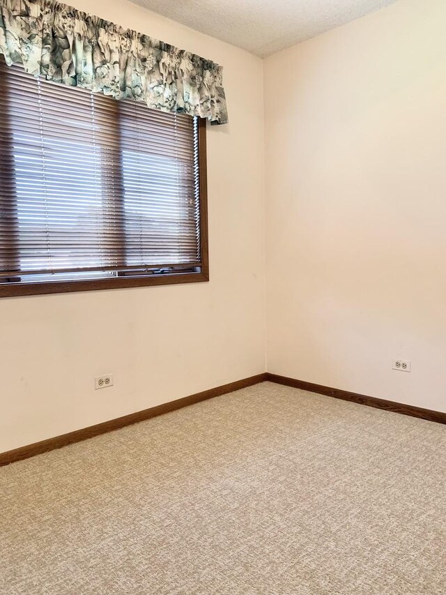 unfurnished room with carpet floors and baseboards