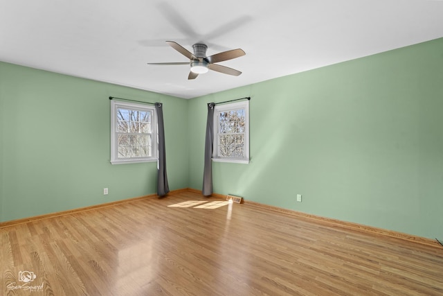 unfurnished room featuring ceiling fan, wood finished floors, and baseboards